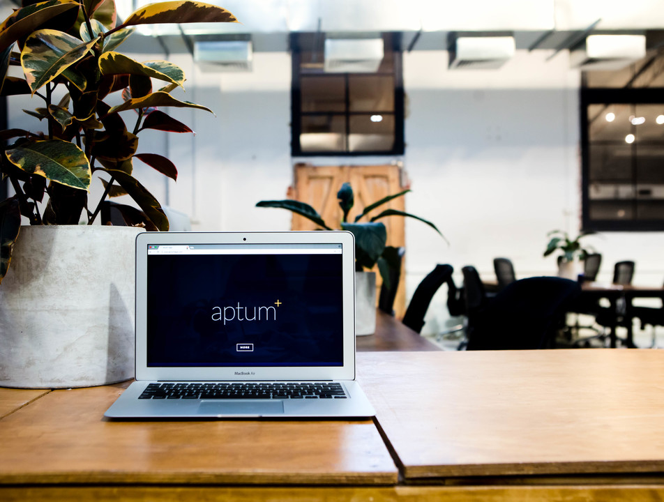 Aptum office with laptop screen displaying Apum logo