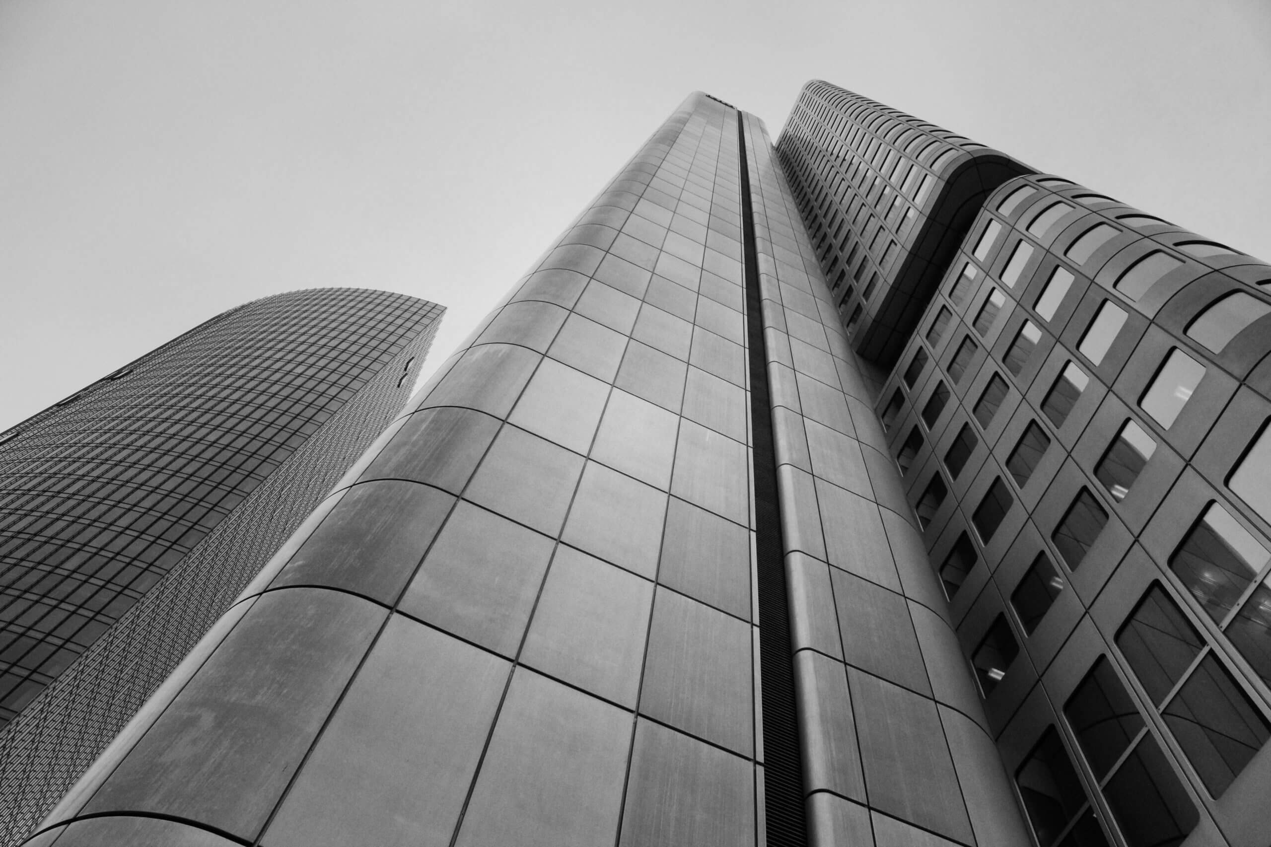 An upwards view at two high-rise buildings on an overcast day