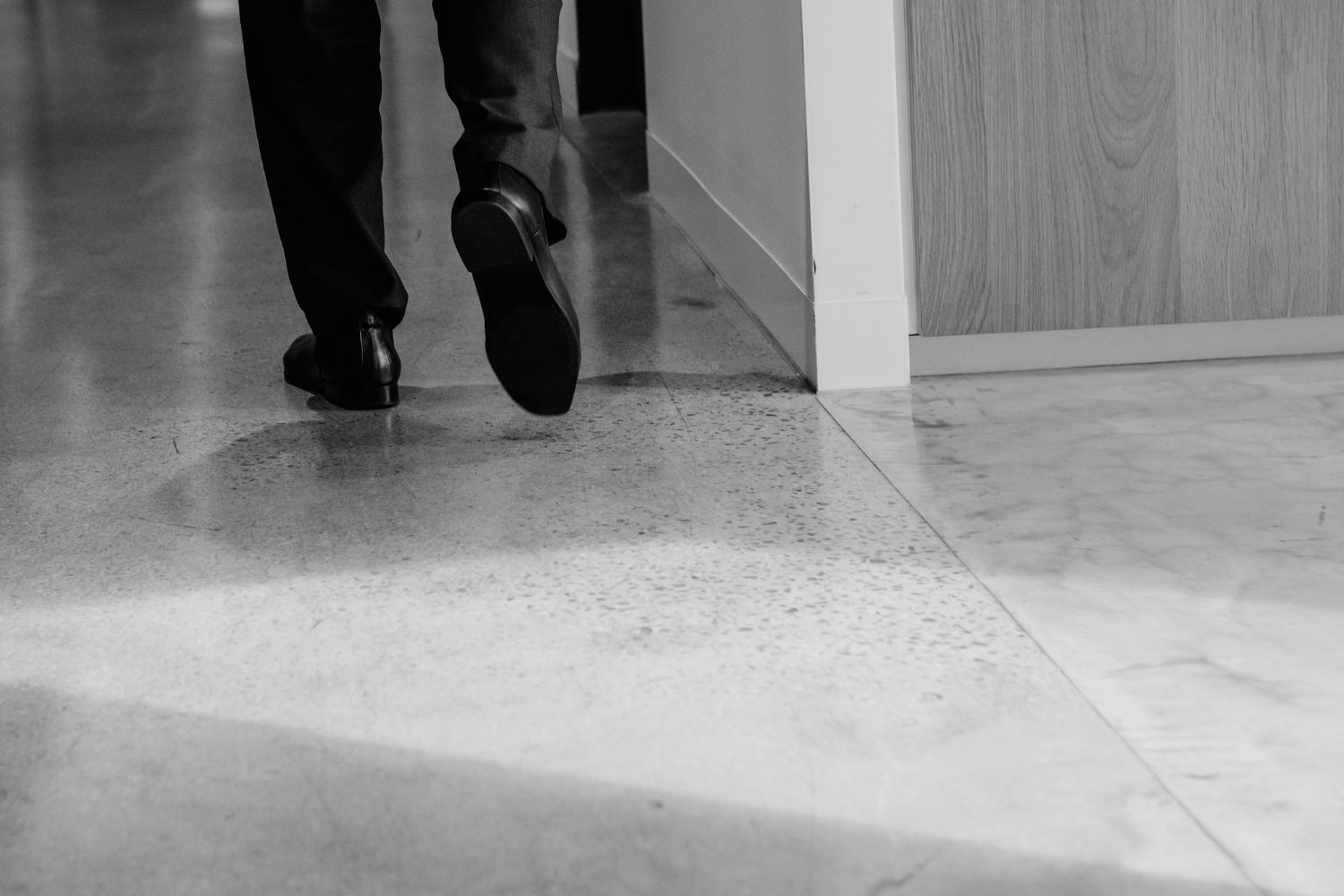 Black and white image of lawyer walking on concrete floor.